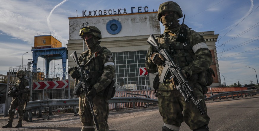 epaselect epa09962096 A picture taken during a media tour organized by the Russian Army shows Russian servicemen standing guard near the Kakhovka Hydroelectric Power Plant (HPP) on the Dnieper River i ...