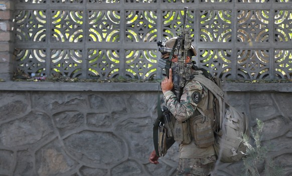 epa08793213 An Afghan special force officer runs toward the scene after an attack at Kabul University in Kabul, Afghanistan, 02 November 2020. At least 19 persons were killed and many others wounded a ...