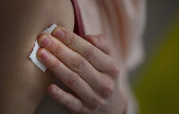 A woman presses a pad onto her upper arm after receiving a dose of Moderna's COVID-19 vaccine at a COVID-19 vaccination and testing site in Brussels, Tuesday. Feb. 9, 2021. Belgium has moved its vacci ...