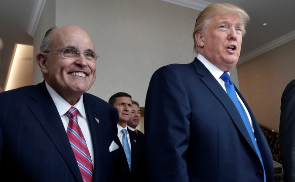 Republican presidential nominee Donald Trump walks with former New York City Mayor Rudolph Giuliani (L) and his son Eric Trumo (R) through the new Trump International Hotel in Washington, D.C., U.S.,  ...