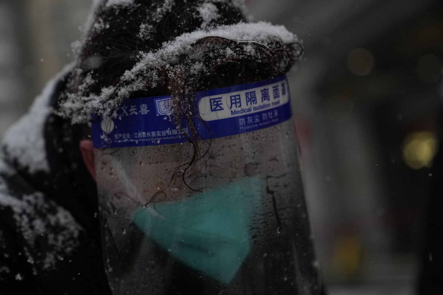 A person&#039;s hair is filled with snow during snowfall at the Beijing Winter Olympics Sunday, Feb. 13, 2022, in Beijing. (AP Photo/Brynn Anderson)