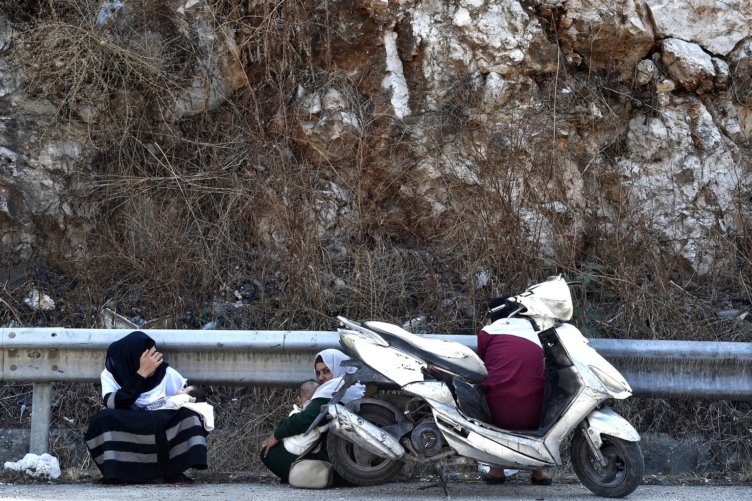 epaselect epa11622250 Lebanese women, who are fleeing southern Lebanon, tend to their babies along the Damour highway as they travel towards Beirut, Lebanon, 24 September 2024. Thousands of people fle ...