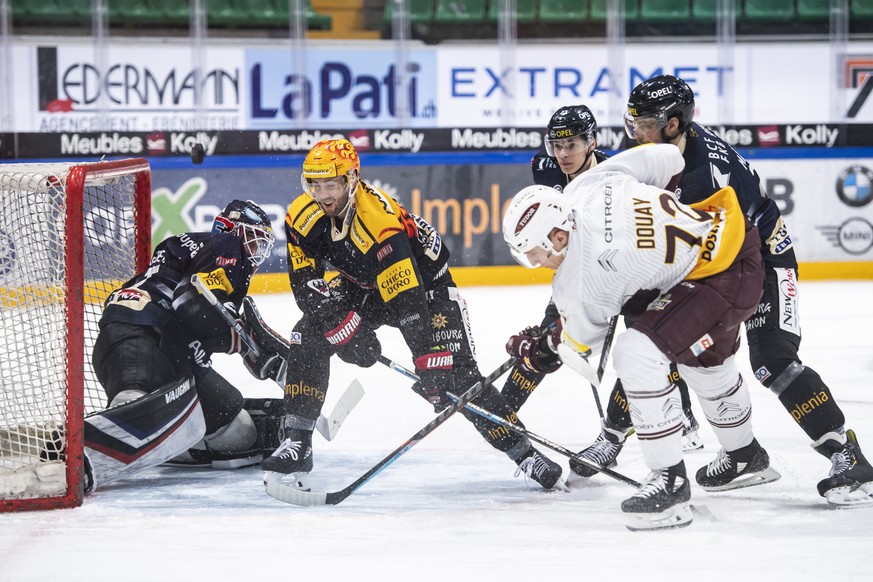 Le gardien Fribourgeois Ludovic Waeber, gauche, lutte pour le puck avec l&#039;attaquant genevois Floran Douay, droite, et le top scorer fribourgeois Ryan Gunderson, centre, lors de la rencontre du ch ...