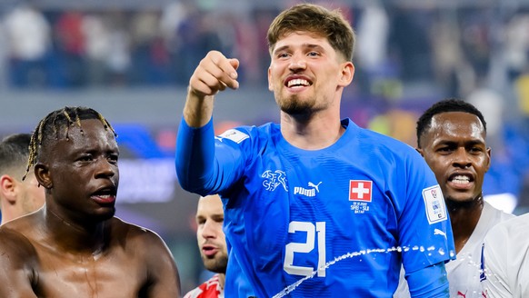 Switzerland's soccer players with midfielder Denis Zakaria, goalkeeper Gregor Kobel, defender Manuel Akanji, from left to right, celebrate the victory and the qualification during the FIFA World ...