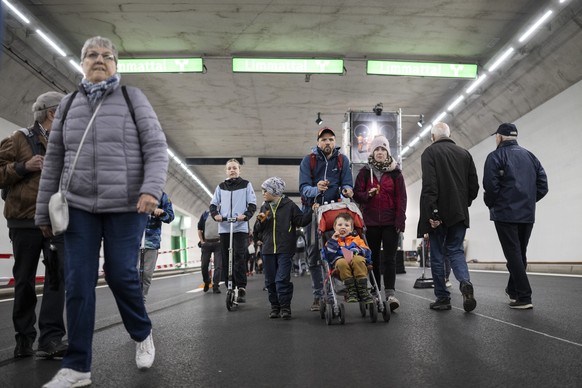 Menschen bewegen sich in der 3. Roehre des Gubristtunnels anlaesslich des Tunnelfests kurz vor der Inbetriebnahme, aufgenommen am Samstag, 15. April 2023 in Zuerich. Die neue, dritte Roehre ist in Ric ...