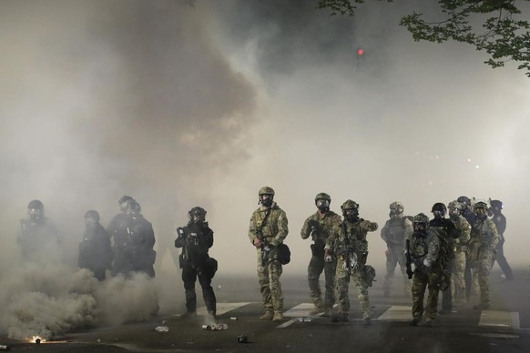 Federal officers advance on demonstrators during a Black Lives Matter protest at the Mark O. Hatfield United States Courthouse Friday, July 24, 2020, in Portland, Ore. (AP Photo/Marcio Jose Sanchez)