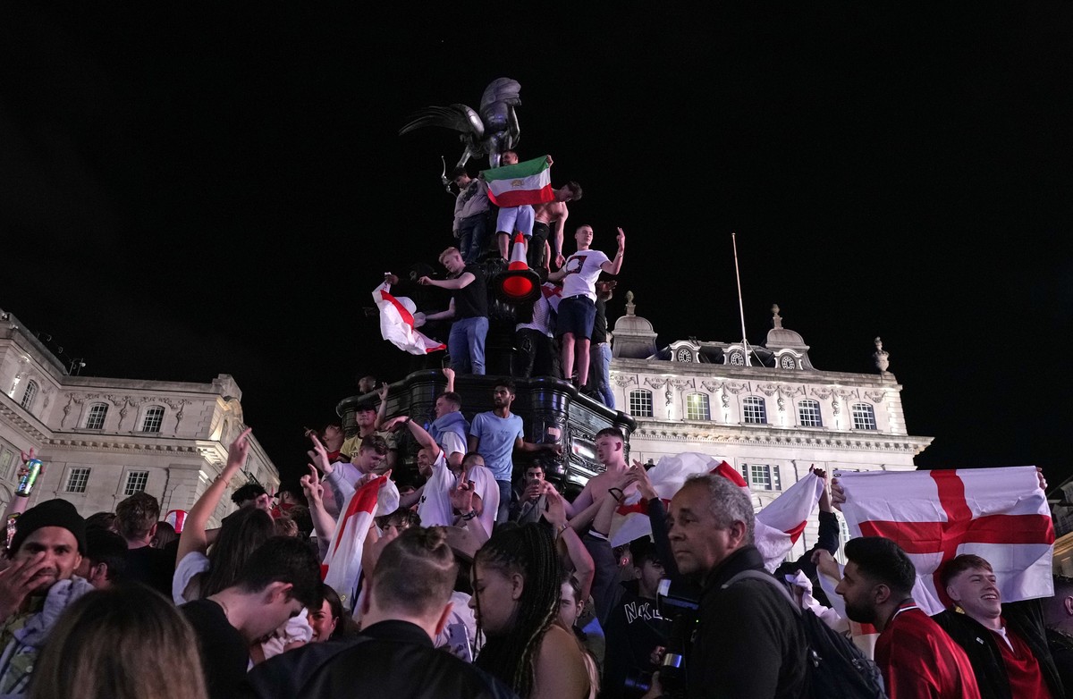 England supporters celebrate by climbing onto the statue of Eros in Piccadilly Circus in London, Saturday, July 3, 2021 after going there to celebrate England's 4-0 win in the Euro 2020 soccer ch ...