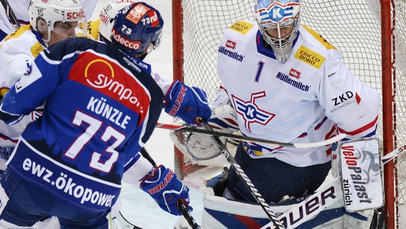 Der Zuercher Mike Kuenzle, Zweiter links, erzielt das 1-0, die Klotener Philippe Schelling, links, und Jonas Mueller, rechts, haben das Nachsehen, beim Eishockey Meisterschaftsspiel der National Leagu ...