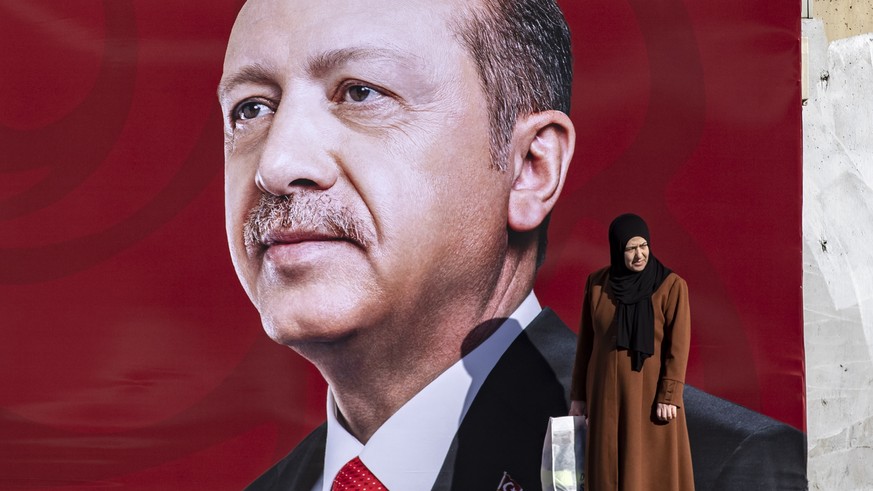 epa10413229 A woman stands in front of a picture of the Turkish President Recep Tayyip Erdogan in Istanbul, Turkey, 18 January 2023. President Erdogan announced that the presidential election could be ...