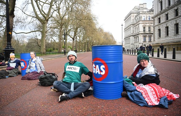 epa09875356 Environmental pressure group Doctors for Extinction Rebellion glue themselves to barrels during a protest outside the Treasury Office in London, Britain, 07 April 2022. The protest was org ...