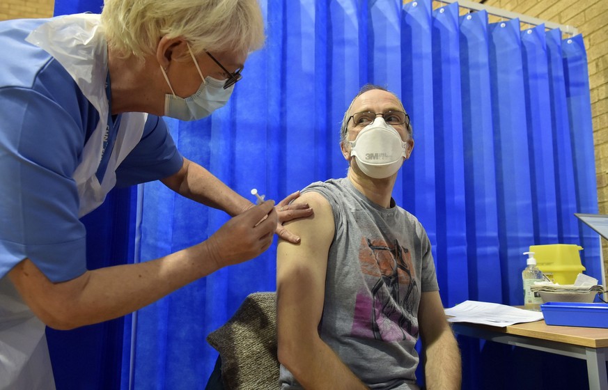 David Farrell, 51, receives the Pfizer-BioNTech COVID-19 vaccine at a vaccination centre in Cardiff, Wales, Tuesday Dec. 8, 2020. The United Kingdom, one of the countries hardest hit by the coronaviru ...