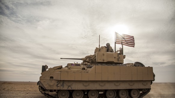 FILE - American soldiers drive a Bradley fighting vehicle during a joint exercise with Syrian Democratic Forces at the countryside of Deir Ezzor in northeastern Syria, Dec. 8, 2021. President Joe Bide ...