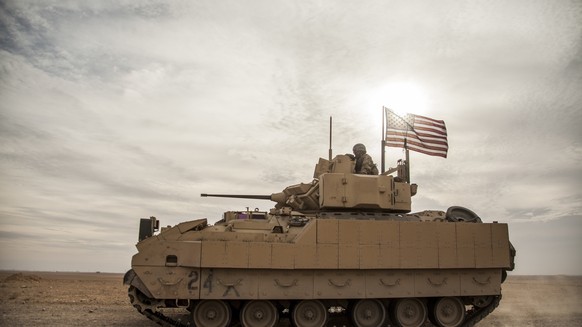 FILE - U.S. soldiers drive a Bradley combat vehicle during a joint exercise with the Syrian Democratic Forces in rural Deir Ezzor in northeastern Syria, December.  8, 2021.President Joe Bide...