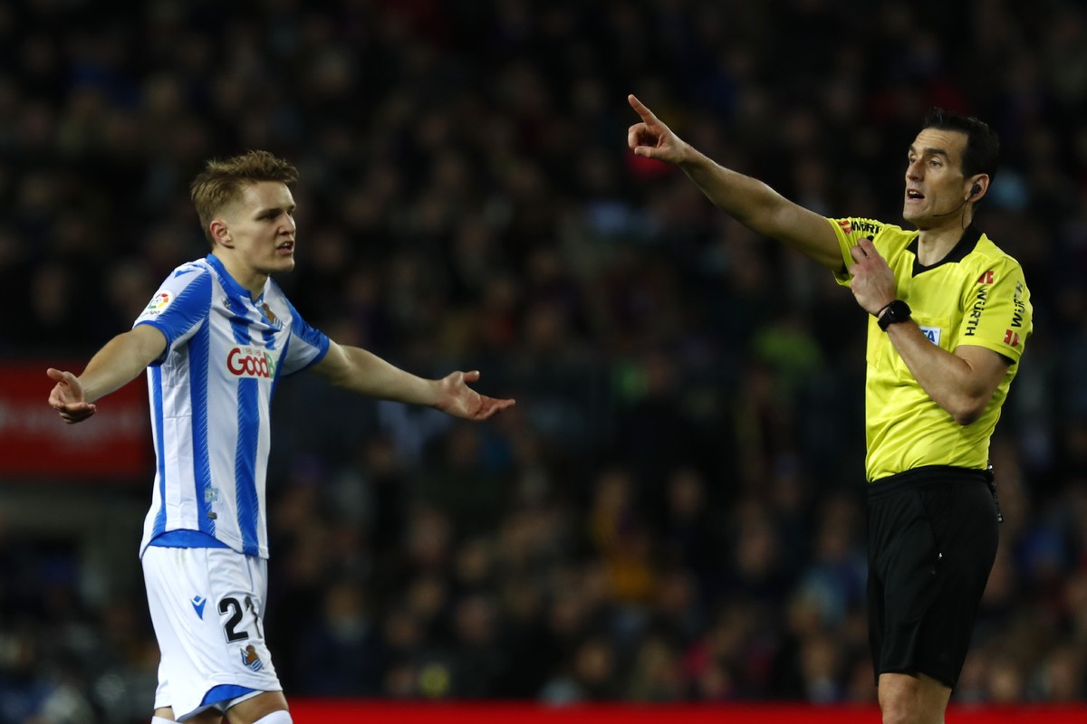 Real Sociedad's Martin Oedegaard, left, reacts as referee Juan Martinez Munuera points to the penalty box after watching the VAR monitor, during a Spanish La Liga soccer match between Barcelona a ...