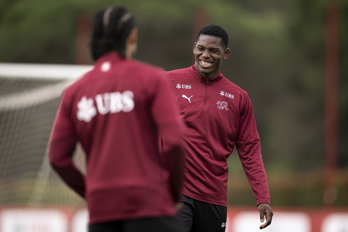 Der Spieler der Schweizer Fussballnationalmannschaft Breel Embolo lacht mit der neue Spieler der Schweizer Fussballnationalmannschaft Isaac Schmidt, um den ball waehrend einem Training, am Donnerstag, ...