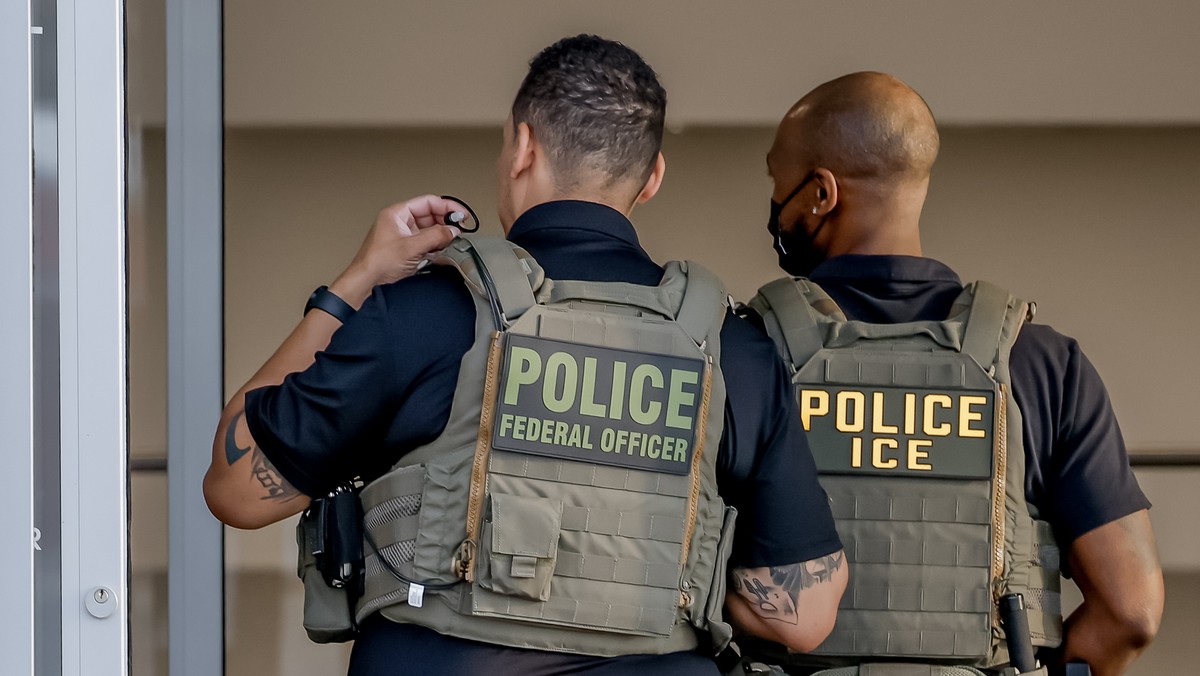 epa12844508 A federal police officer and a US Immigration and Customs Enforcement (ICE) agent monitor air passengers waiting in long TSA security screening checkpoint lines at Hartsfield-Jackson Atlan ...