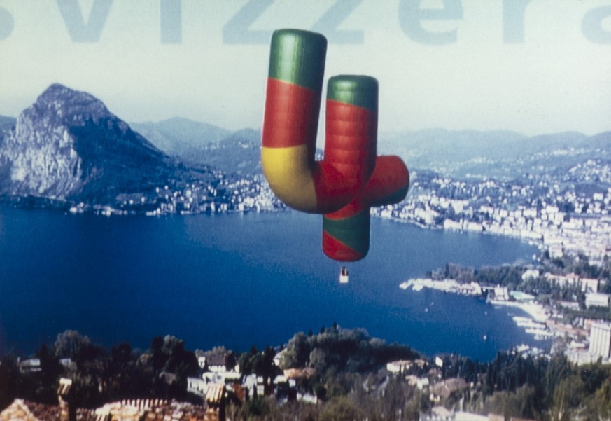 Das Kennzeichen von Schweiz4, einem Fernsehprogramm der SRG, waren von einem Hubschrauber aus aufgenommene Luftaufnahmen eines ueber der Schweizer Landschaft fliegenden Heissluftballons in Form einer  ...