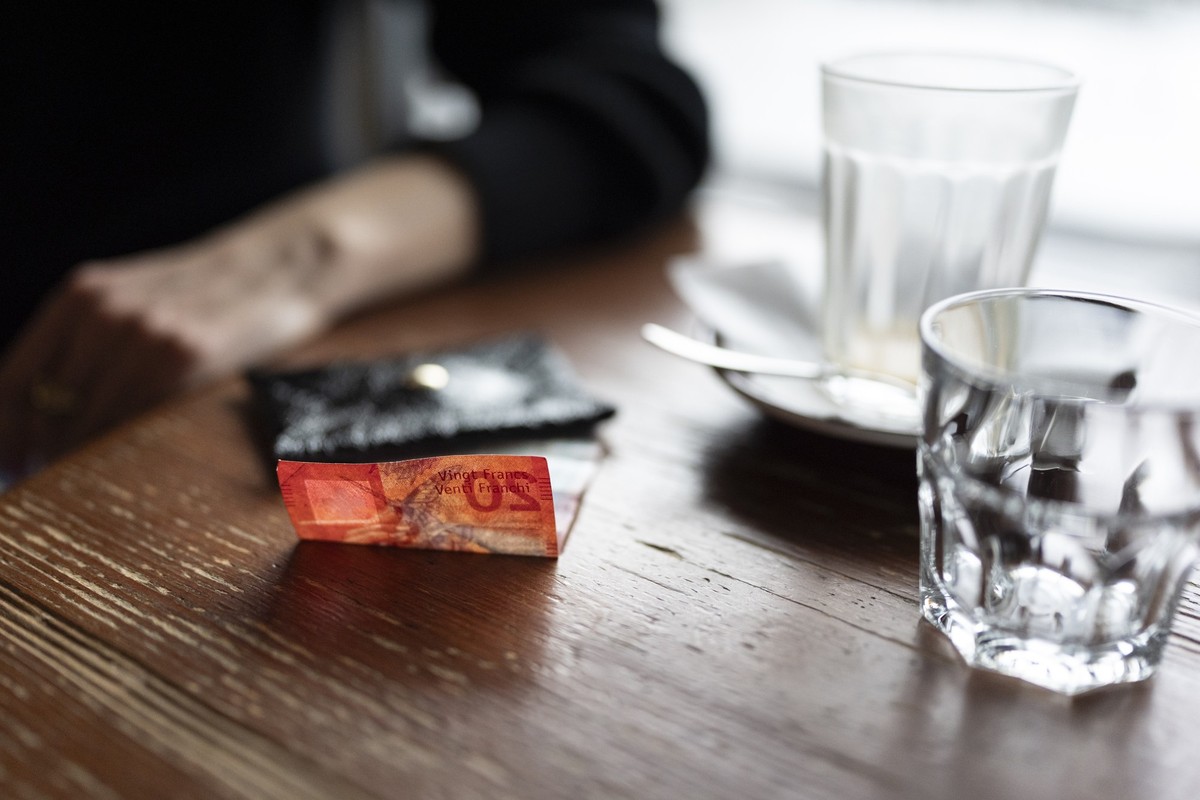 Eine Frau wartet, um den Kaffee in einer Bar mit Bargeld zu bezahlen, fotografiert am Dienstag, 16. Dezember 2025 in Zuerich. (KEYSTONE/Gaetan Bally)
