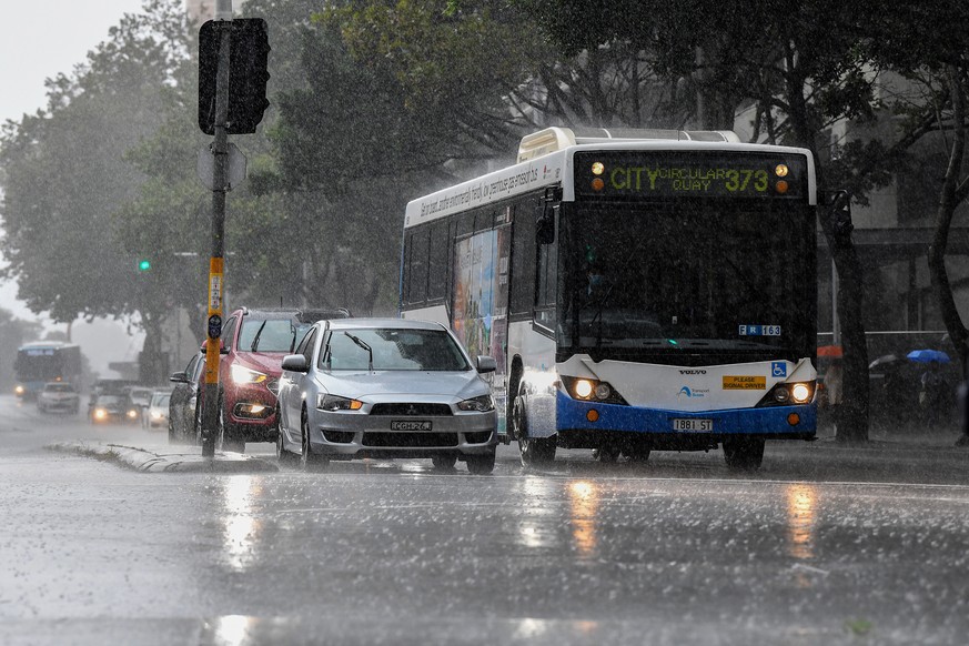 epa09089171 Traffic is seen in heavy rain in Sydney, Australia, 22 March 2021. Rivers are bursting their banks and dams are overflowing and many residents are on standby to leave their homes as heavy  ...