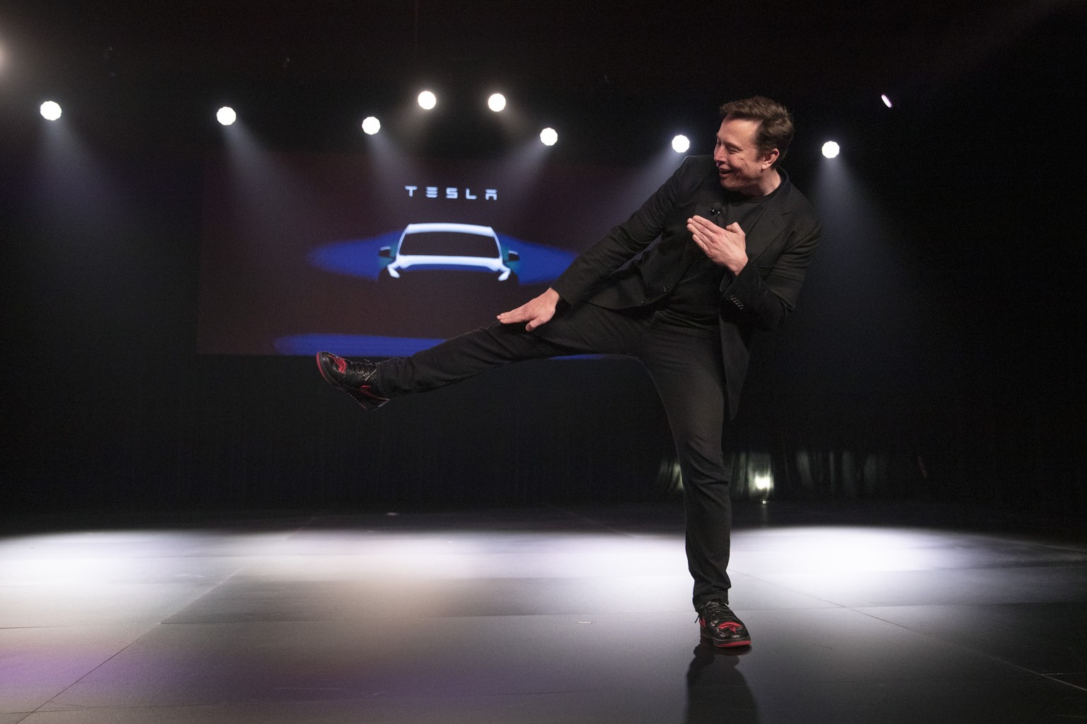 Tesla CEO Elon Musk jokingly motions to kick before introducing the Model Y at Tesla&#039;s design studio Thursday, March 14, 2019, in Hawthorne, Calif. The Model Y may be Tesla&#039;s most important  ...