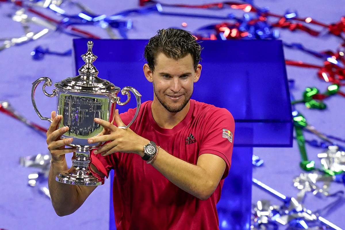 Dominic Thiem, of Austria, holds up the championship trophy after defeating Alexander Zverev, of Germany, in the men's singles final of the US Open tennis championships, Sunday, Sept. 13, 2020, i ...