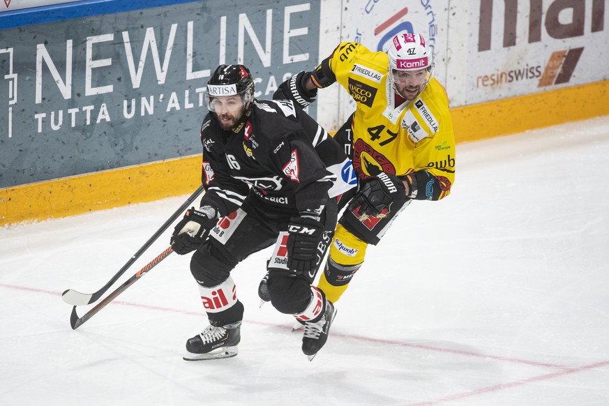 From left, Lugano&#039;s player Raphael Herburger and Bern&#039;s player Sven Baertschi, during the preliminary round game of the National League 2022/23 between HC Lugano and SC Bern at the ice stadi ...