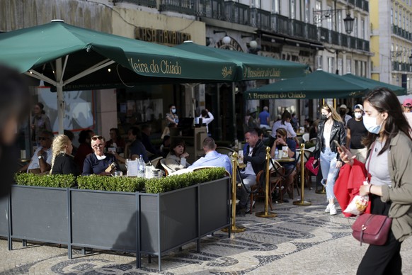 People sit a cafe terrace in downtown Lisbon, Friday, June 4, 2021. Britain said Thursday that it is removing Portugal from its list of COVID-safe travel destinations, meaning thousands of U.K. reside ...