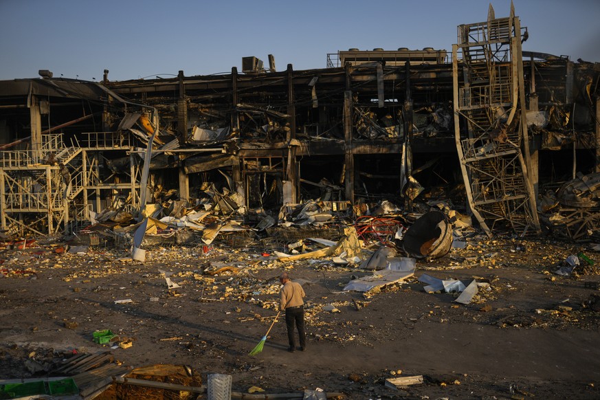 A man sweeps rubble next to a shopping and entertainment mall in Odessa, Ukraine, Friday, May 13, 2022, destroyed after Russian missiles strike on May 9. (AP Photo/Francisco Seco)