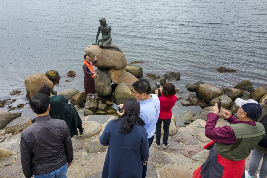 Touristen machen Erinnerungsfotos vor der Bronzestatue Kleine Meerjungfrau (Den Lille Havfrue) in Kopenhagen, Daenemark, am Samstag, 12. Oktober 2019. (KEYSTONE/Georgios Kefalas)
