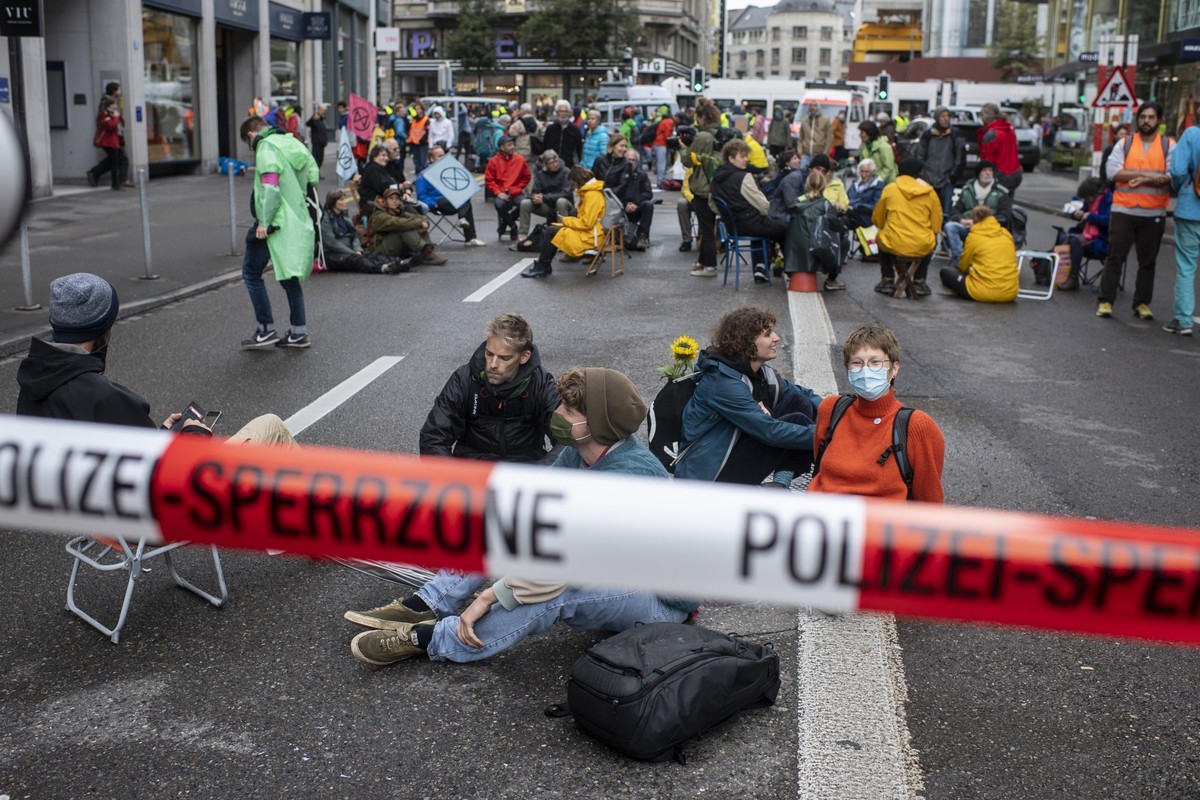 Aktivisten der Klimaorganisation "Extinction Rebellion" blockieren eine Strasse in der Zuercher Innenstadt, aufgenommen am Montag, 4. Oktober 2021 in Zuerich. (KEYSTONE/Ennio Leanza)