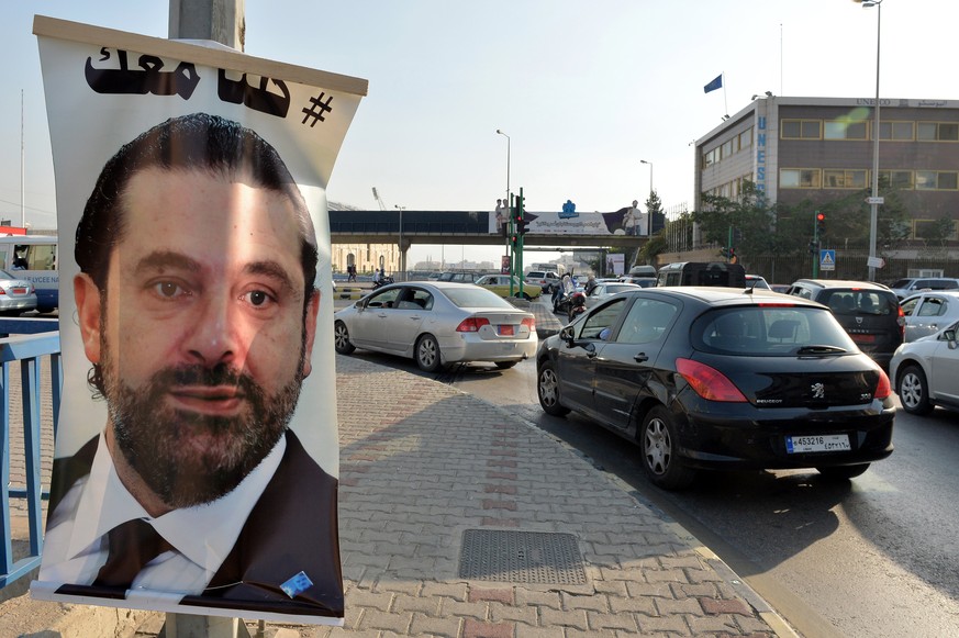 epa06328646 A poster depicting Prime Minister Saad Hariri, who has resigned as Lebanese Prime Minister, with Arabic words that read &#039;We are all with you&#039; hangs on a street in Beirut, Lebanon ...