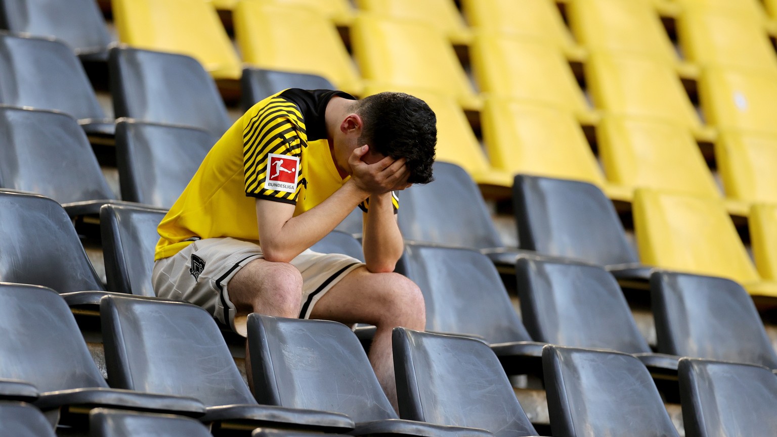 epa10657928 A dejected fan of Borussia Dortmund after the German Bundesliga match between Borussia Dortmund and Mainz 05 in Dortmund, Germany, 27 May 2023. The match ended 2-2 and both Bayern Munich a ...