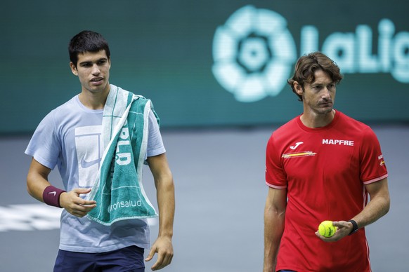 epa10183592 Spanish tennis player Carlos Alcaraz (L) next to his coach Juan Carlos Ferrero (R) take part in a training session ahead of the Davis Cup tennis match between Spain and Serbia, in Valencia ...