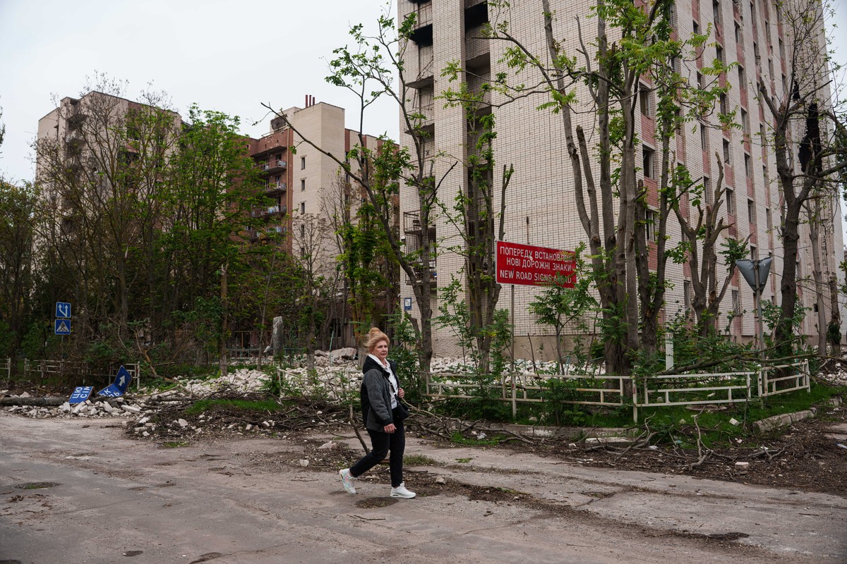 A local woman walks in front of a residential building damaged in a Russian attack during a local ceasefire related to a humanitarian aid mission in Oleshky, in Kherson, Ukraine, Wednesday, Oct. 28, 2 ...