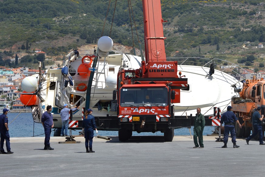 epa04192262 A crane lifts a yacht after two boats carrying migrants capsized, at Malagari port on Samos Island, Greece, 05 May 2014. At least 18 people were confirmed drowned and as many as a dozen st ...