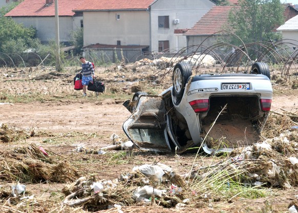 A man walks next to wrecked car after heavy floods in Cento near Skopje, Macedonia, August 7, 2016. REUTERS/Stringer FOR EDITORIAL USE ONLY. NO RESEALES. NO ARCHIVE