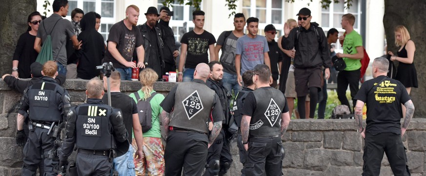 epa05540805 A picture made available on 15 September 2016 shows police officers watching members from various camps during a gathering at the Kornmarkt square in Bautzen, Germany, 10 September 2016. P ...