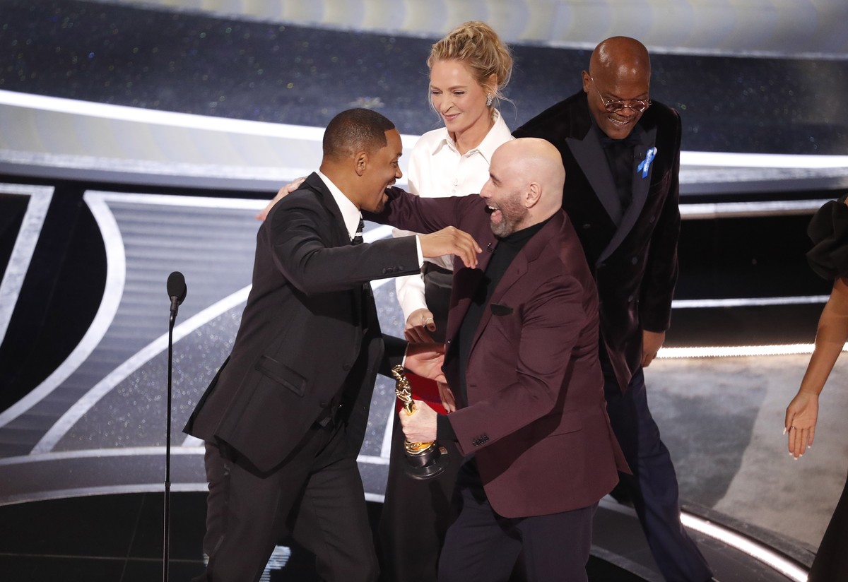 epa09854880 Us actor Will Smith (L) reacts as John Travolta presents him with the Oscar for Best Actor for 'King Richard' during the 94th annual Academy Awards ceremony at the Dolby Theatre  ...