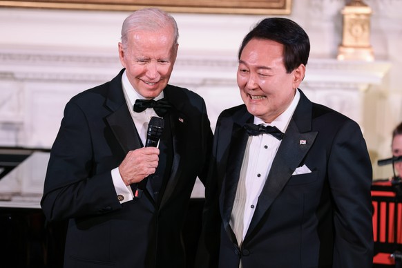 epa10593749 South Korean President Yoon Suk-yeol (R) of the Republic of Korea holds and US President Joe Biden speak during the State Dinner held in the East Room of The White House in Washington, DC, ...