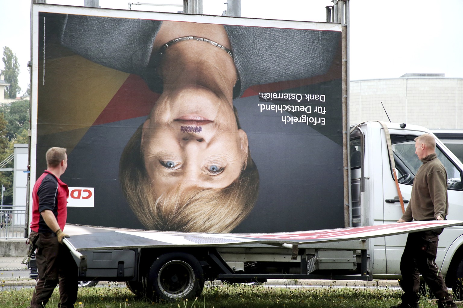 Workers remove an election poster of the Christian Democrats with a photo of German chancellor Angela Merkel in Berlin, Monday, Sept. 25, 2017 after Sunday&#039;s parliament elections. German Chancell ...