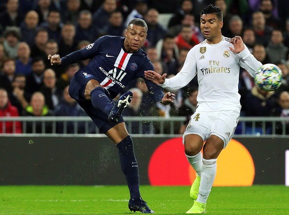 epa08027679 Real Madrid&#039;s Carlos Casemiro (R) in action against PSG&#039;s Kylian Mbappe (L) during the UEFA Champions League group A soccer match between Real Madrid and Paris Saint-Germain at S ...