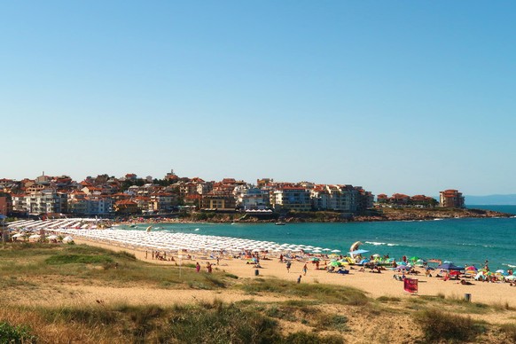 View onto Harmanite, Kharmanite on a busy day, many white beach umbrellas and sun chairs on the beach, the intense turquoise blue sea and the town of Sozopol, Sosopol in the background, Bulgaria, View ...
