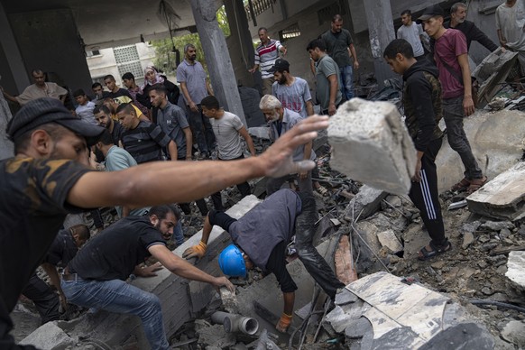 Palestinians look for survivors in a building destroyed during Israeli bombardment in Rafah refugee camp in Gaza Strip on Tuesday, Oct. 17, 2023. (AP Photo/Fatima Shbair)