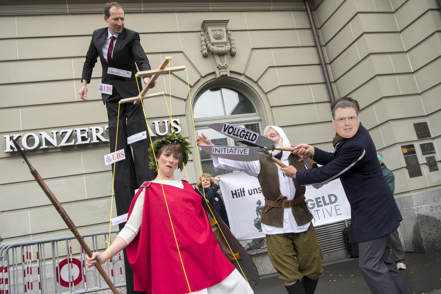 Aktivisten des Komitees &quot;Vollgeld-Initiative&quot; protestieren mit einer Marionetten-Helvetia, Mitte, und einer Maske von SNB Praesident Thomas Jordan, rechts, vor der 109. SNB Generalversammlun ...