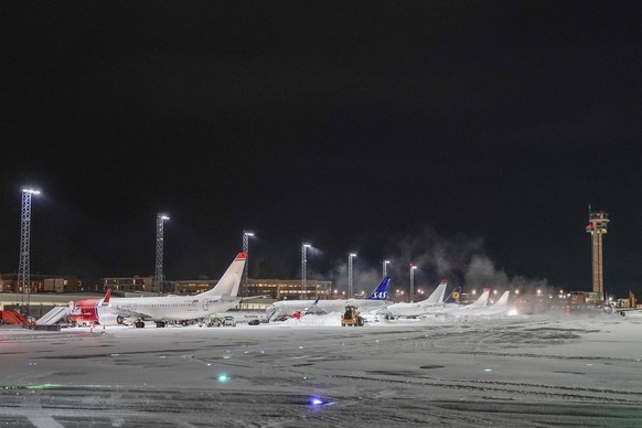 News Bilder des Tages Kraftig snofall Gardermoen 20240117. Fly parkert ved terminalbygget mens broytemannskaper rydder unna sno pa Oslo Lufthavn Gardermoen onsdag ettermiddag. Foto: Cornelius Poppe /  ...