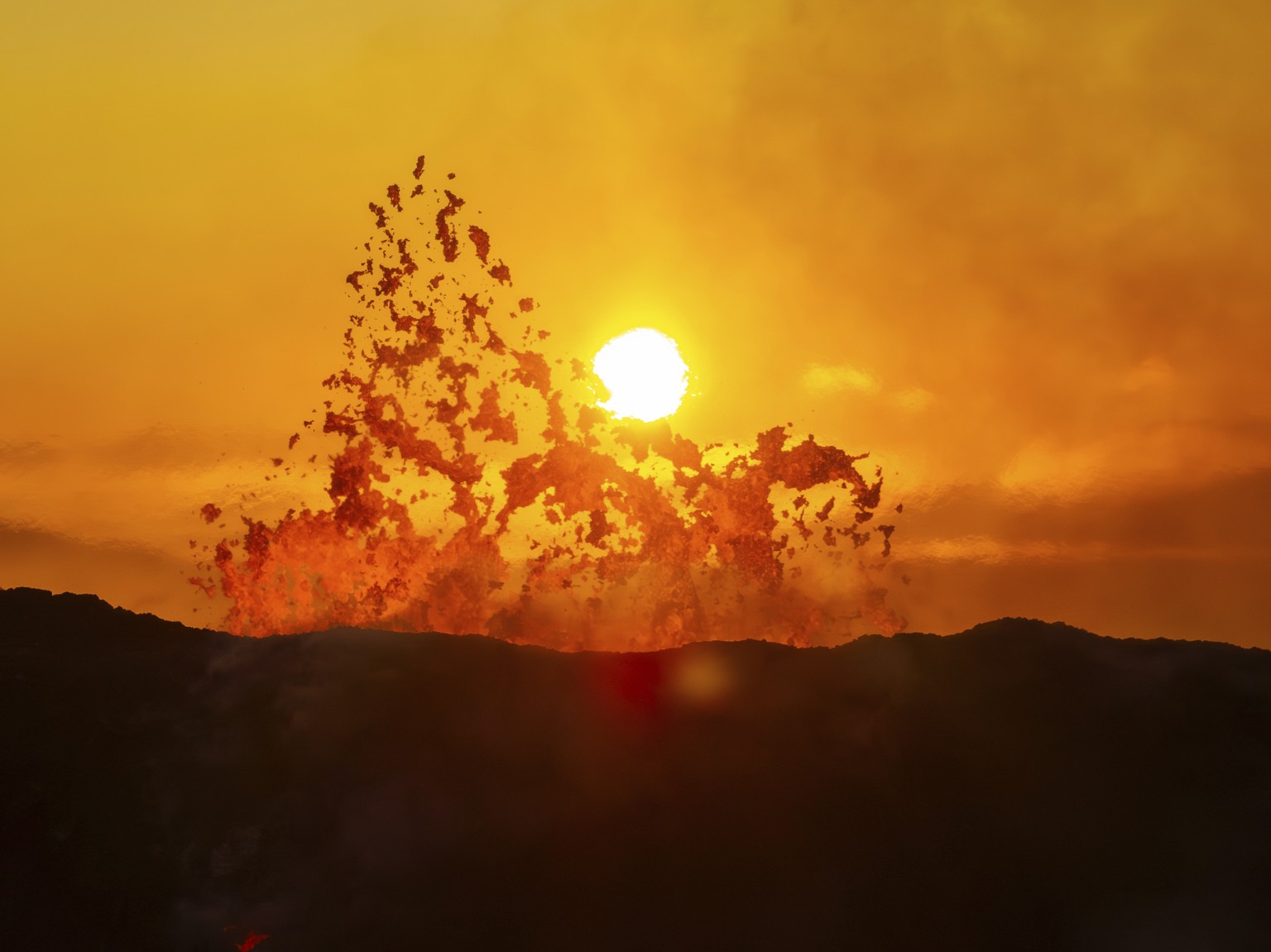 The sun rises above the active crater of the volcano near Grindavik, Iceland, Monday, June 10, 2024. A volcano in southwestern Iceland has been erupting spewing red lava close to the coastal town of G ...