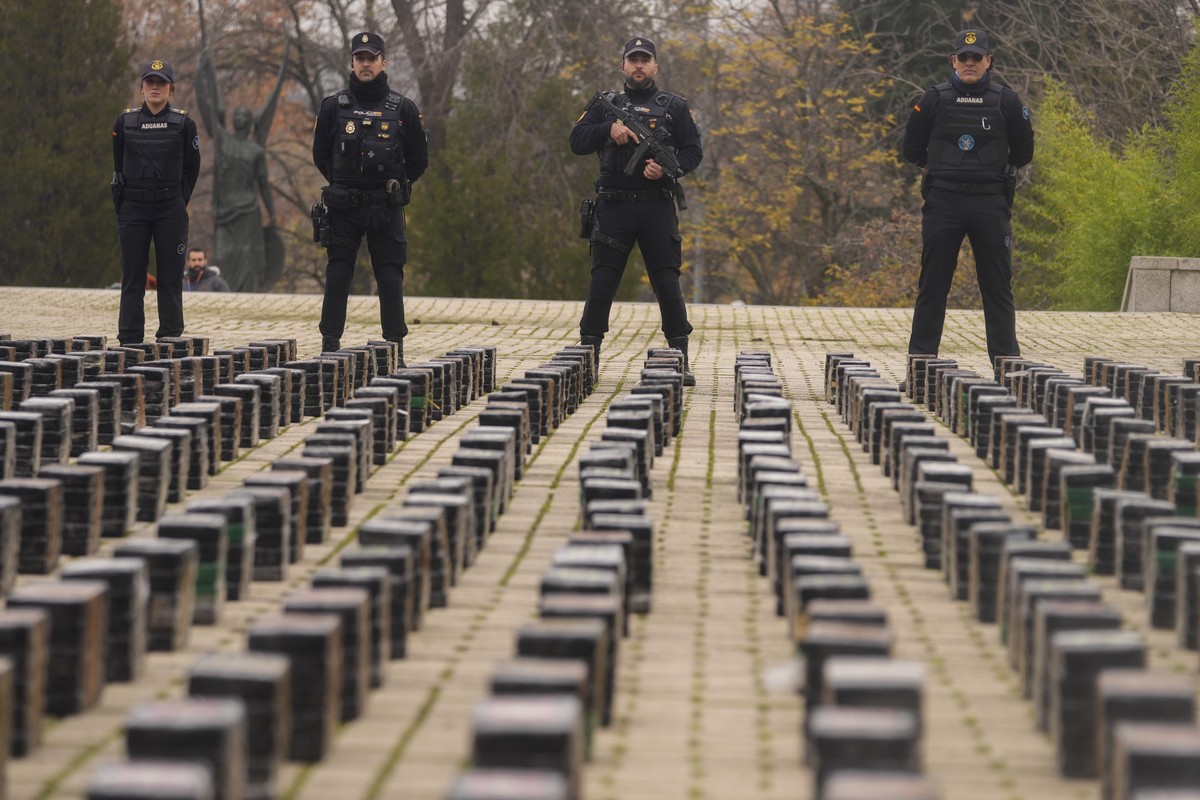 Police officers stand by part of a haul of 11 tons of cocaine, displayed in the patio of a police station in Madrid, Spain, Tuesday, Dec. 12, 2023. Spanish authorities say that they have confiscated 1 ...