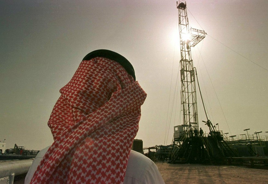 FILE - In this Feb. 26, 1997 file photo, Khaled al-Otaiby, an official of the Saudi oil company Aramco, watches progress at a rig at the al-Howta oil field near Howta, Saudi Arabia. According to an as ...