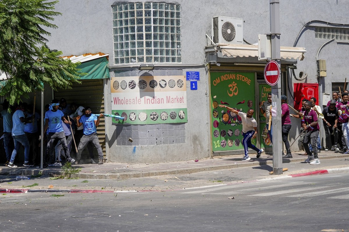 Anti-Eritrean government activists, left, clash with supporters of the Eritrean government, in Tel Aviv, Israel, Saturday, Sept. 2, 2023. Hundreds of Eritrean asylum seekers smashed shop windows and p ...