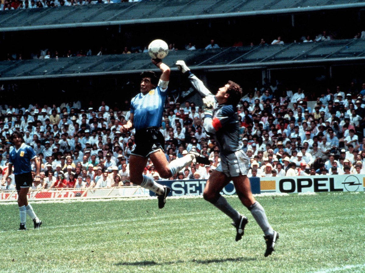 Eine beruehmte und vieldiskutierte Szene der Fussball-WM-Geschichte vom 22. Juni 1986 mit Tatort Aztekenstadion in Mexiko-Stadt: Die argentinische Fussball-Legende Diego Maradona (M) boxt in der 51. M ...